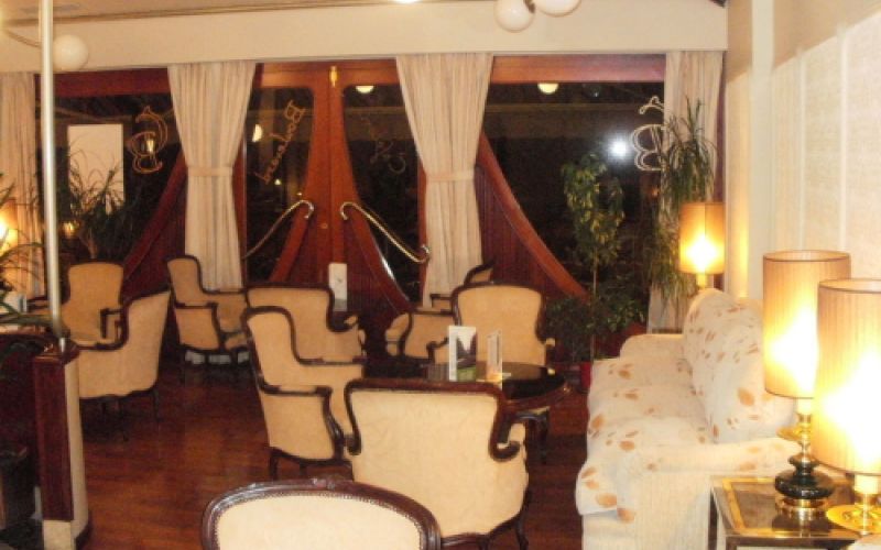 Interior de la cafetería con grupos de sillas clásicas blancas y mesas negras