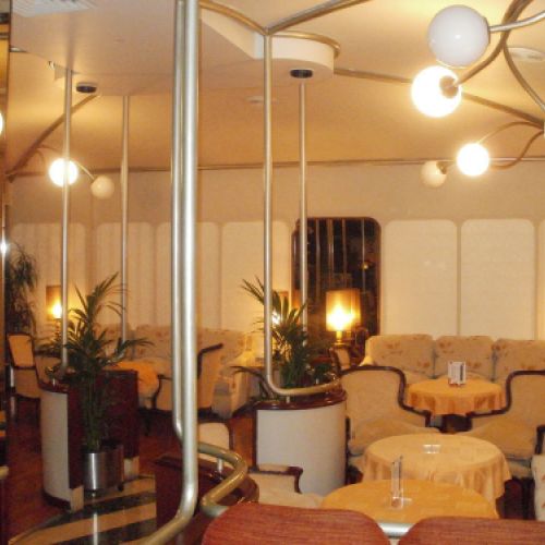 Interior de la cafetería con espejos y lámparas clásicas de globos