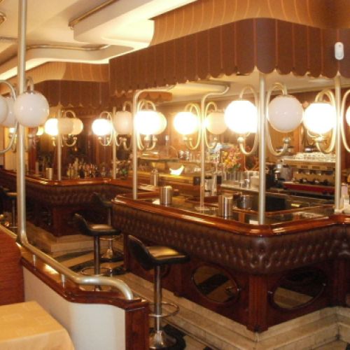 Interior de la cafetería con butacas a la izquierda y barra a la derecha